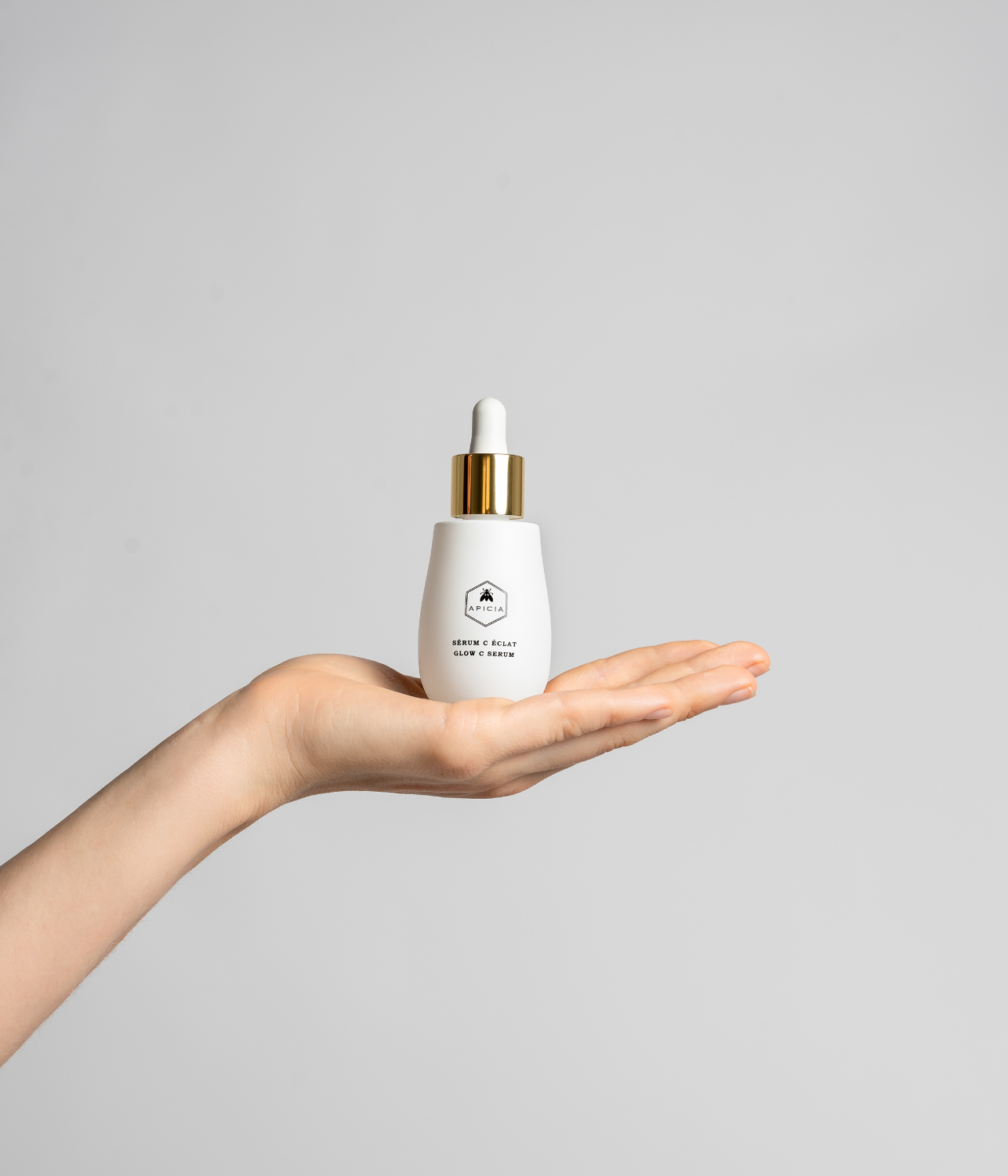 Hand holding a white serum