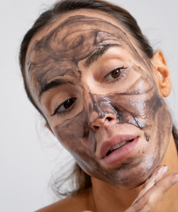 Femme qui s'applique un masque détox noir